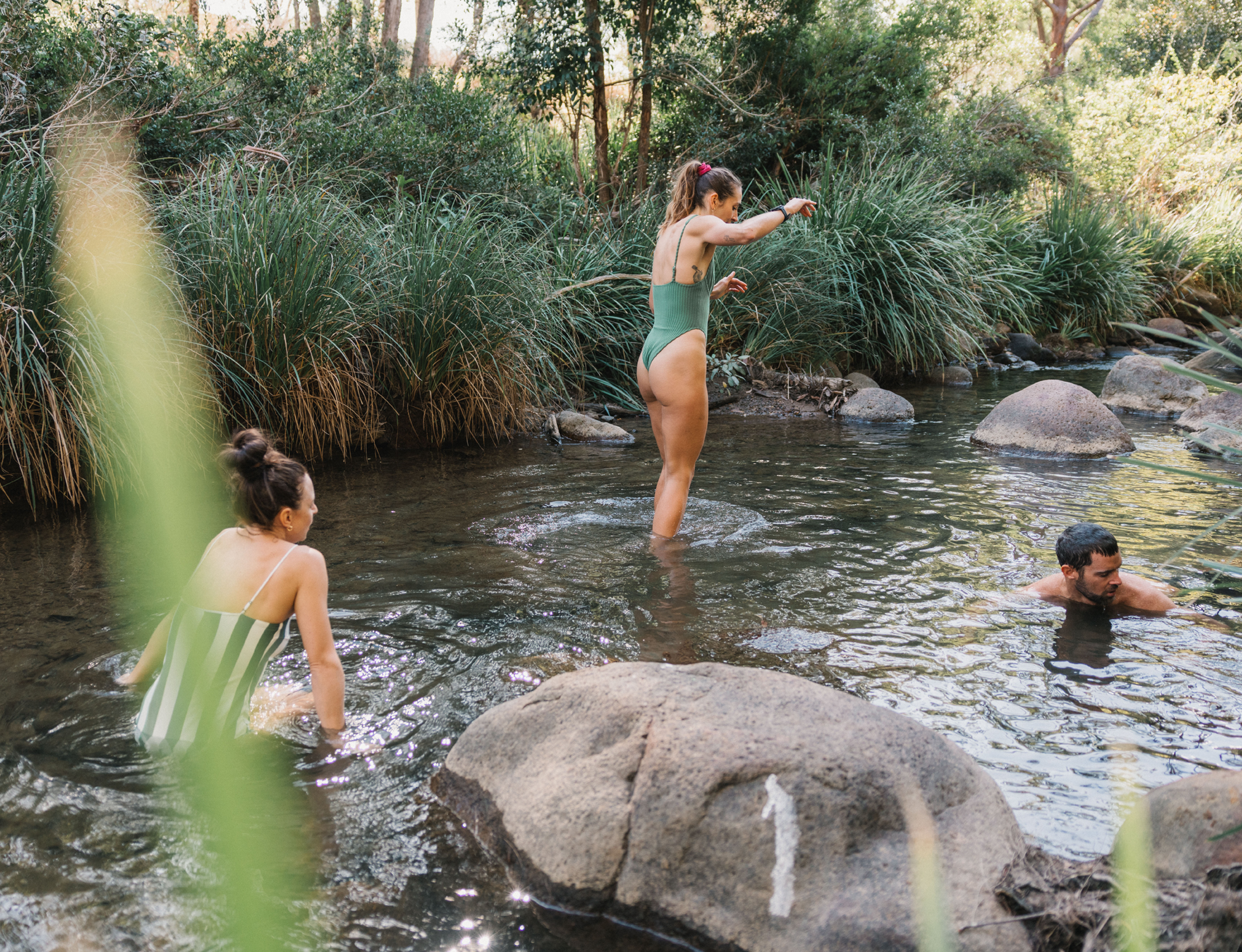 People play in a shallow creek